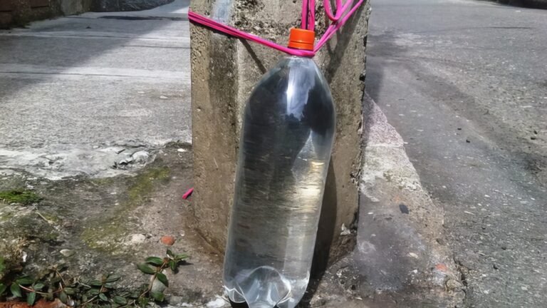 Bouteille d'eau attachée à un poteau en Colombie